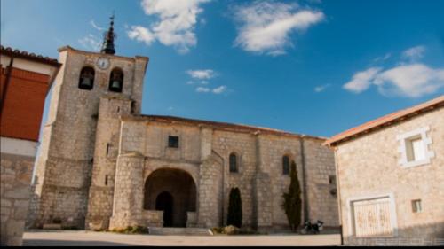 a large stone building with a clock tower on it at Hotel Rural Quintanapalla in Quintanapalla