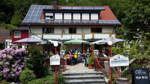 um grupo de pessoas do lado de fora de uma casa com painéis solares em Pension Goldmann - Ferienwohnung 3 em Schönau im Schwarzwald