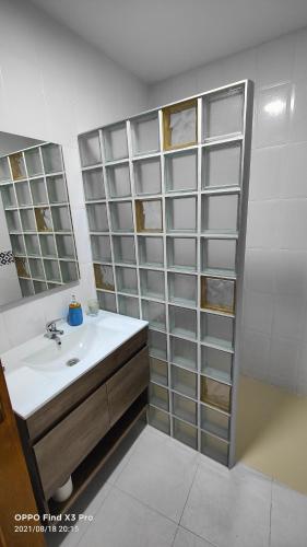 a bathroom with a sink and glass shelves at Alojamiento Rural El Peñon de Hornos in Hornos