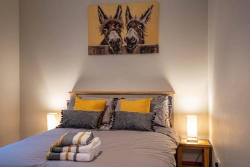 1 dormitorio con 1 cama con 2 caballos en la pared en Cozy Newly Renovated Town Centre Apartment, en Aberfeldy