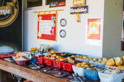a buffet with baskets of bread and other food at Pousada Quintal da Lua in Capitólio
