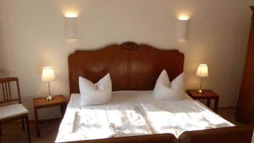 um quarto com uma cama com 2 almofadas e 2 candeeiros em Gut Rattelvitz, Parterre B em Gingst