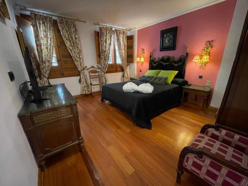 a bedroom with a bed in a room with pink walls at La Llave de la Judería Hotel Boutique in Córdoba