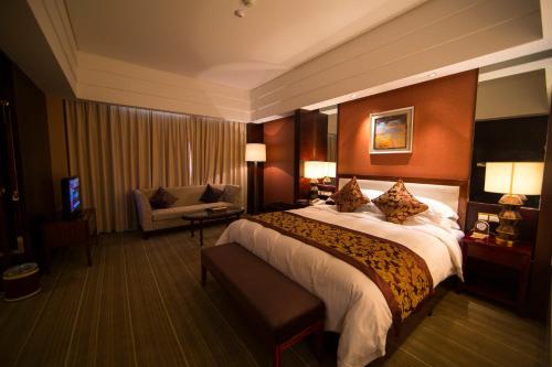 Habitación de hotel con cama grande y sofá en Seercuo International Hotel, en Songpan