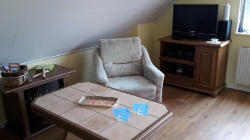 een woonkamer met een stoel en een tafel bij Fewo im "Schwedenhaus" in Prerow