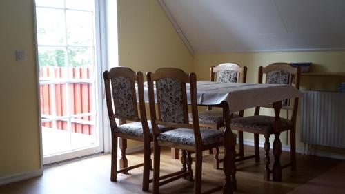een eettafel en stoelen met een tafel en een raam bij Fewo im "Schwedenhaus" in Prerow