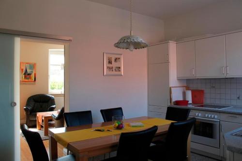 a kitchen with a table and chairs and a dining room at Zollhaus Strukkamp in Strukkamp auf Fehmarn