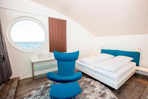 ノイシュタット・イン・ホルシュタインにあるKYST 5410 Floating Home 2のベッドルーム1室(ベッド1台、青い椅子付)