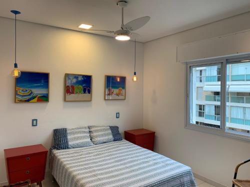 un dormitorio con una cama y una ventana en Apê Descolado no Guarujá - Enseada, en Guarujá