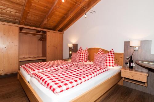 a bedroom with a red and white bed and a sink at Riederstein Nr 8 in Bad Wiessee