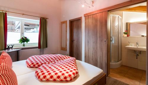 um quarto com duas almofadas vermelhas e brancas numa cama em Riederstein Nr 8 em Bad Wiessee