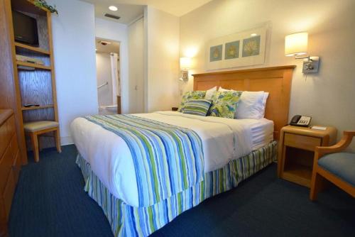 a hotel room with a large bed and a chair at Laguna Surf in Laguna Beach