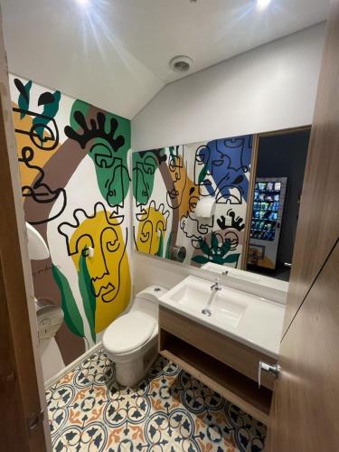 a bathroom with a toilet and a sink and a mirror at ExpoStay Hotel Corferias Embajada Americana in Bogotá