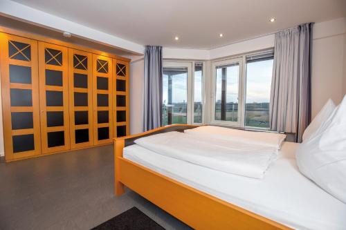 a bedroom with a bed and a large window at ancora Marina Haus 2 Penthouse in Neustadt in Holstein
