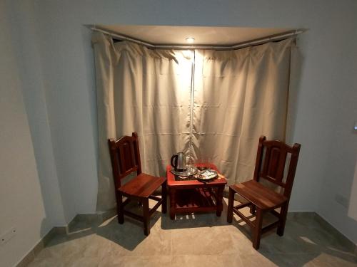 a small table with two chairs and a curtain at Habitación con baño privado en edificio 1er piso in San Salvador de Jujuy