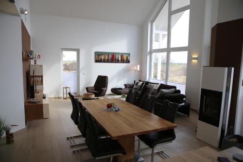 uma sala de estar com uma mesa de madeira e cadeiras pretas em Villa Meerfreude em Trent