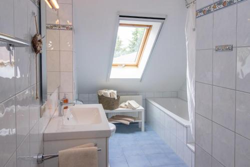 a bathroom with a sink and a tub and a window at Huxfeld-Hof - Wörpe in Grasberg