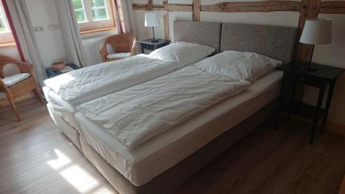 a large bed with white sheets in a bedroom at Lüdersburger Strasse 15c in Lüdersburg