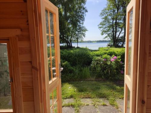 an open door to a view of the water at Glamping POD in Wittenborn