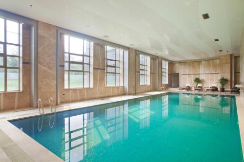 a large swimming pool with blue water in a building at Holiday Inn Mudanjiang, an IHG Hotel in Mudanjiang