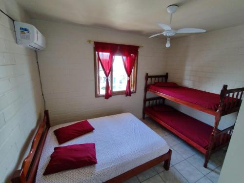 a bedroom with two bunk beds and a window at Residencial BomAluguel in Capão da Canoa