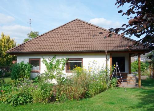 een wit huis met een bruin dak bij Ferienwohnung Neupert in Nübbel