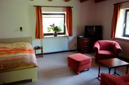 a bedroom with a bed and a chair and a window at Ferienwohnung Neupert in Nübbel