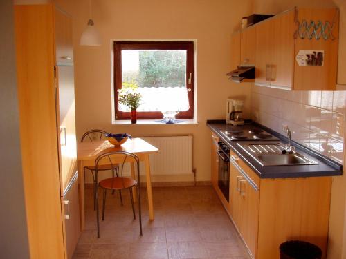 een kleine keuken met een tafel en een raam bij Ferienwohnung Neupert in Nübbel