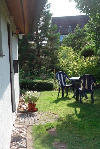 een patio met 2 stoelen en een tafel in het gras bij Ferienwohnung Neupert in Nübbel