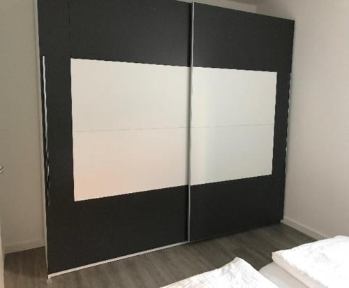 a black and white cabinet in a bedroom at Moderne Ferienwohnung im Herzen von Bad Neustadt in Bad Neustadt an der Saale