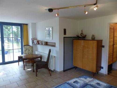 a living room with a table and a chair at Bungalow Am Bahndamm 22 in Zingst