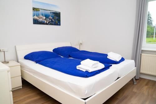 a bedroom with a bed with blue and white sheets at Schleiblick App 15 - barrierearm in Karschau