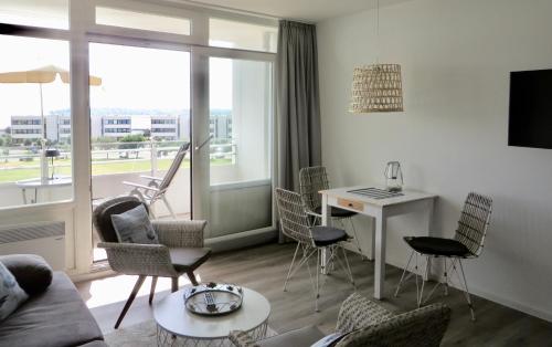 een woonkamer met een bank, stoelen en een tafel bij Strandbude Fehmarn in Fehmarn