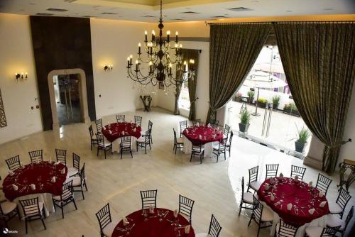 a dining room with red tables and chairs and a chandelier at Posada de Maria Hotel Boutique & Spa in Durango