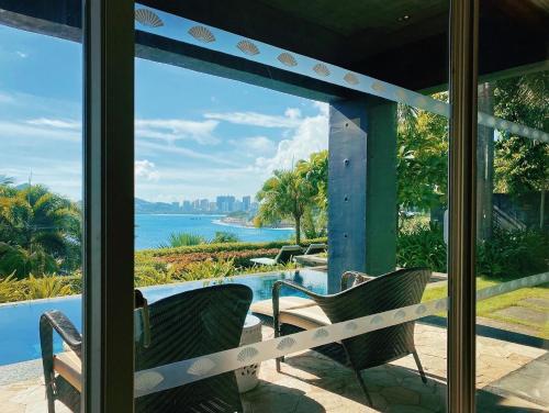 a view of the ocean from the porch of a house at Mandarin Oriental, Sanya in Sanya