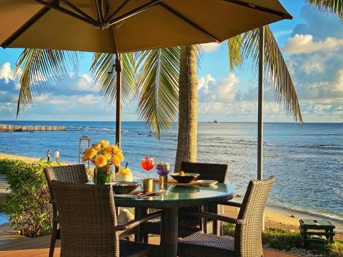 a table with chairs and an umbrella on the beach at Mandarin Oriental, Sanya in Sanya