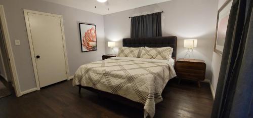 a bedroom with a bed and two lamps and a door at The Harby Street House - Close to U of H, Stadiums, Downtown, Med Center in Houston