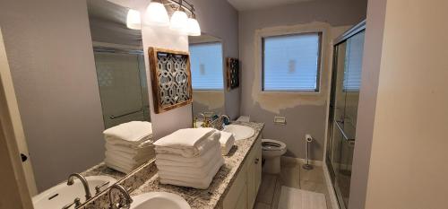 a bathroom with two sinks and a toilet and a mirror at The Harby Street House - Close to U of H, Stadiums, Downtown, Med Center in Houston