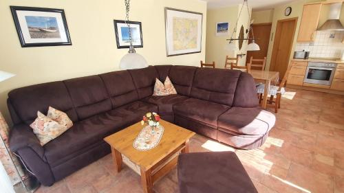 a living room with a brown couch and a table at Birkenstraße 7 Whg 3 in Zingst