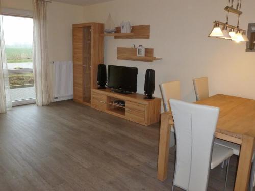 a living room with a dining room table and a television at Fehmarnstrand 78 RH 6 in Staberdorf