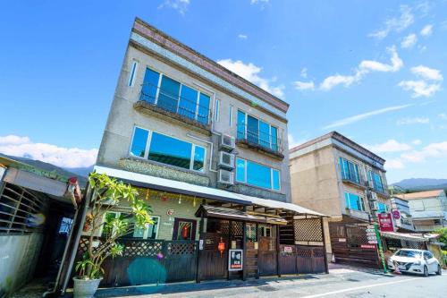 a tall building with blue windows on a street at Sunny Homestay in Jian