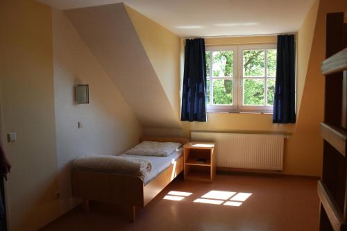 a small bedroom with a bed and a window at Ferienwohnung 4 Struven Hus in Lehe