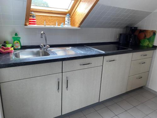 a kitchen with a sink and a counter top at Kreutzmann Ferienwohnung für einen erholsamen Urlaub in ruhiger, zentraler Lage in Heiligenhafen