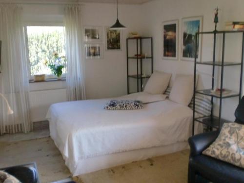 a bedroom with a white bed and a window at Ostseebrise 2 in Zingst
