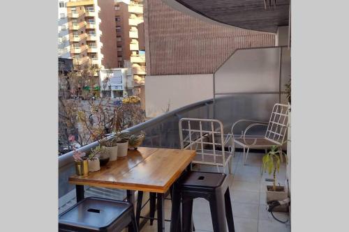 a balcony with a wooden table and chairs on a building at Departamento Ecofriendly excelente ubicación in Cordoba