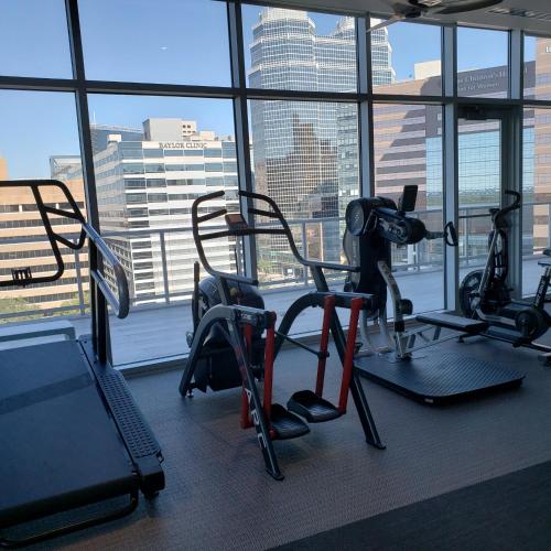 a gym with cardio equipment in front of a window at Latitude Med Center in Houston