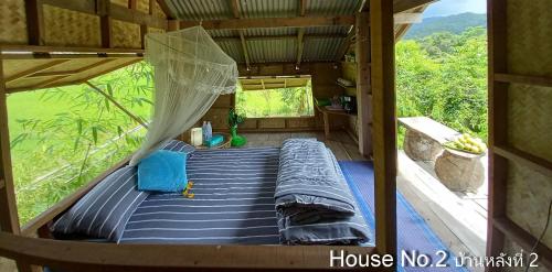 a bed in the inside of a tree house at Chinopuu Hut Homestay Muangkong ชิโนปู ฮัท โฮมสเตย์ เมืองคอง เชียงดาว in Mueang Khong