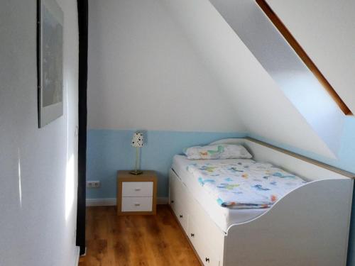 a small bedroom with a bed and a night stand at Ostsseeferienoase Steilküste in Klütz