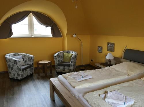 sypialnia z 2 łóżkami i 2 krzesłami oraz oknem w obiekcie Kapitän ParowWindjammer FW 11 w Zingst