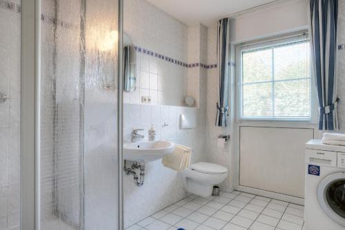 a bathroom with a toilet and a sink and a shower at Strandkieker 14, PP innen in Zingst